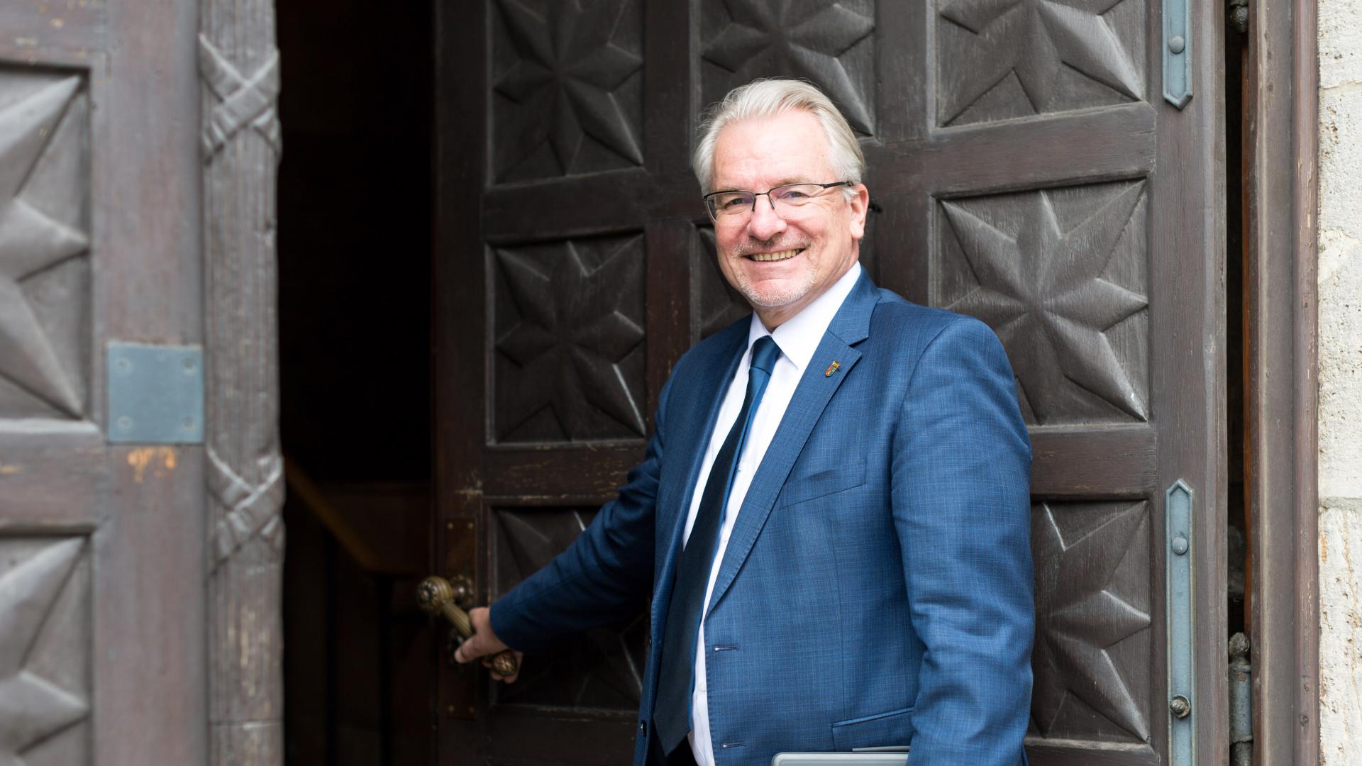 Oberbürgermeister Marc Buchholz öffnet die hölzerne Eingangstür des Rathauses