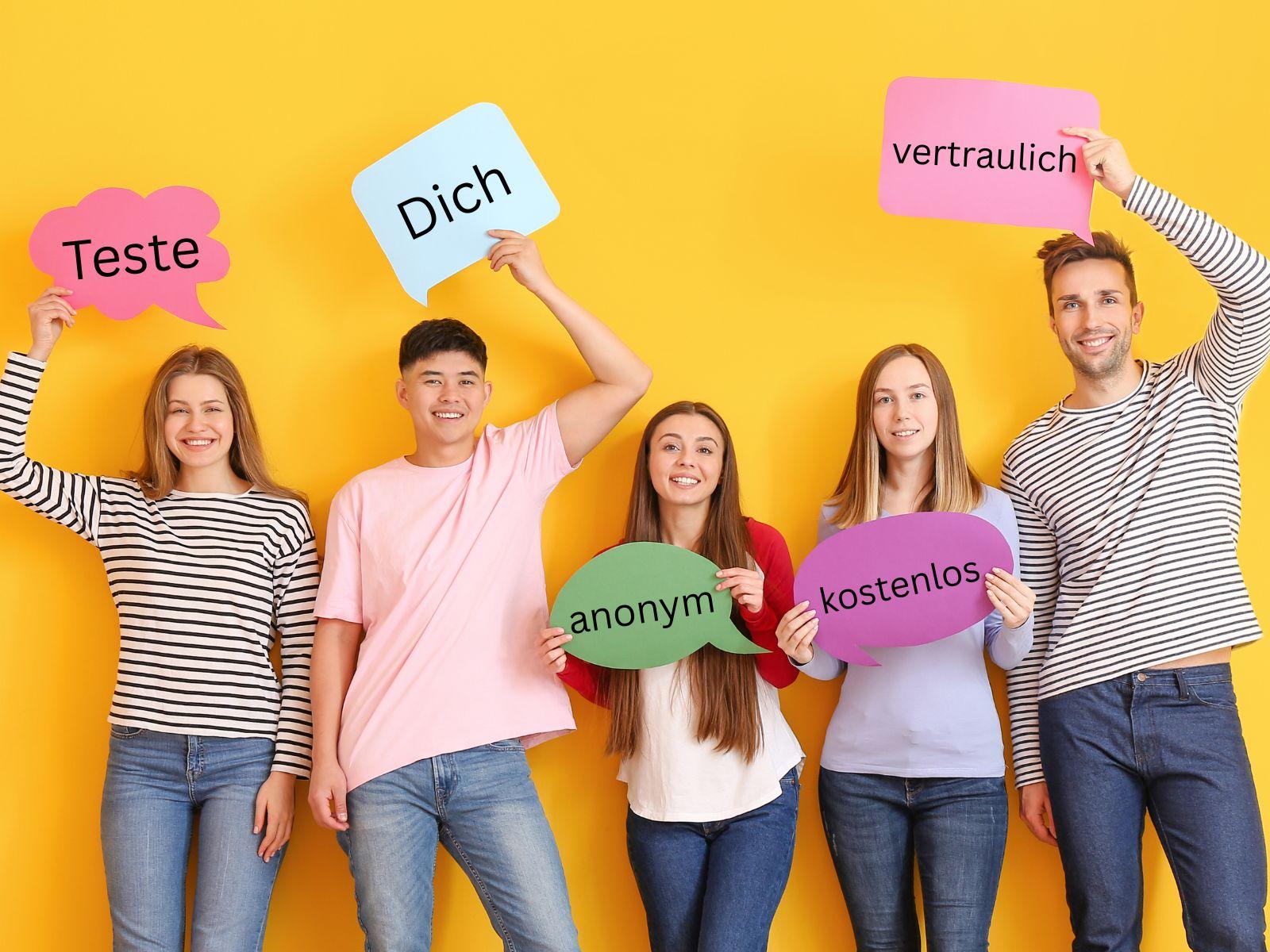 Drei junge Frauen und zwei junge Männer halten Schilder in die Kamera mit den Worten: Teste Dich anonym, kostenlos, vertraulich.