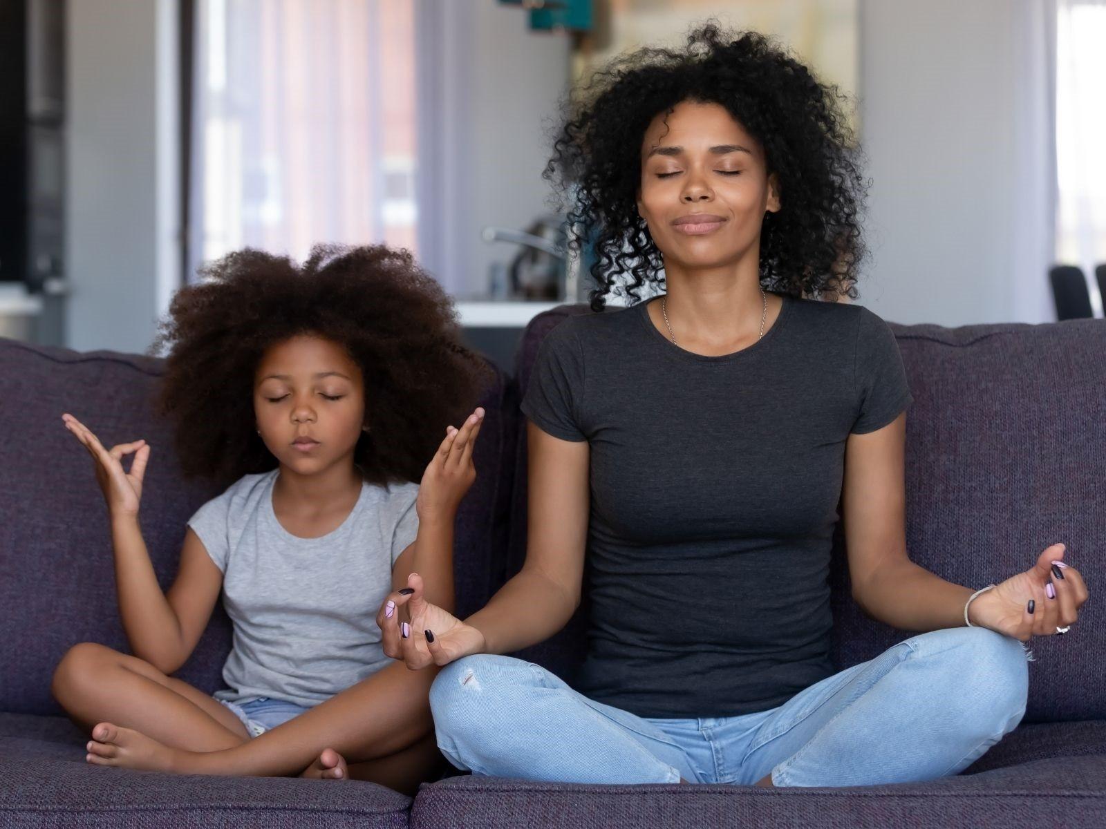 Mutter und Tochter zusammen im Yoga-Schneidersitz.