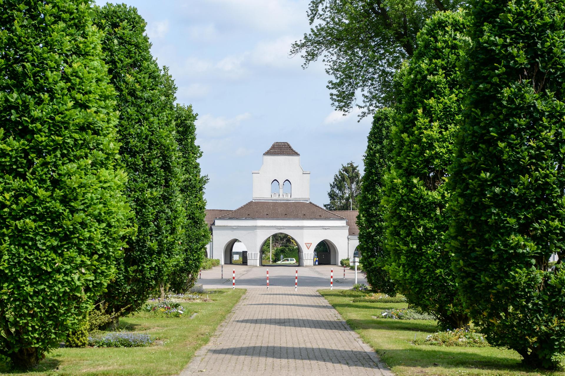 Das denkmalgeschützte Hauptgebäude am Hauptfriedhof, von der Eichenallee aus. Zu sehen ist das Eingangsportal mit dem Glockenturm