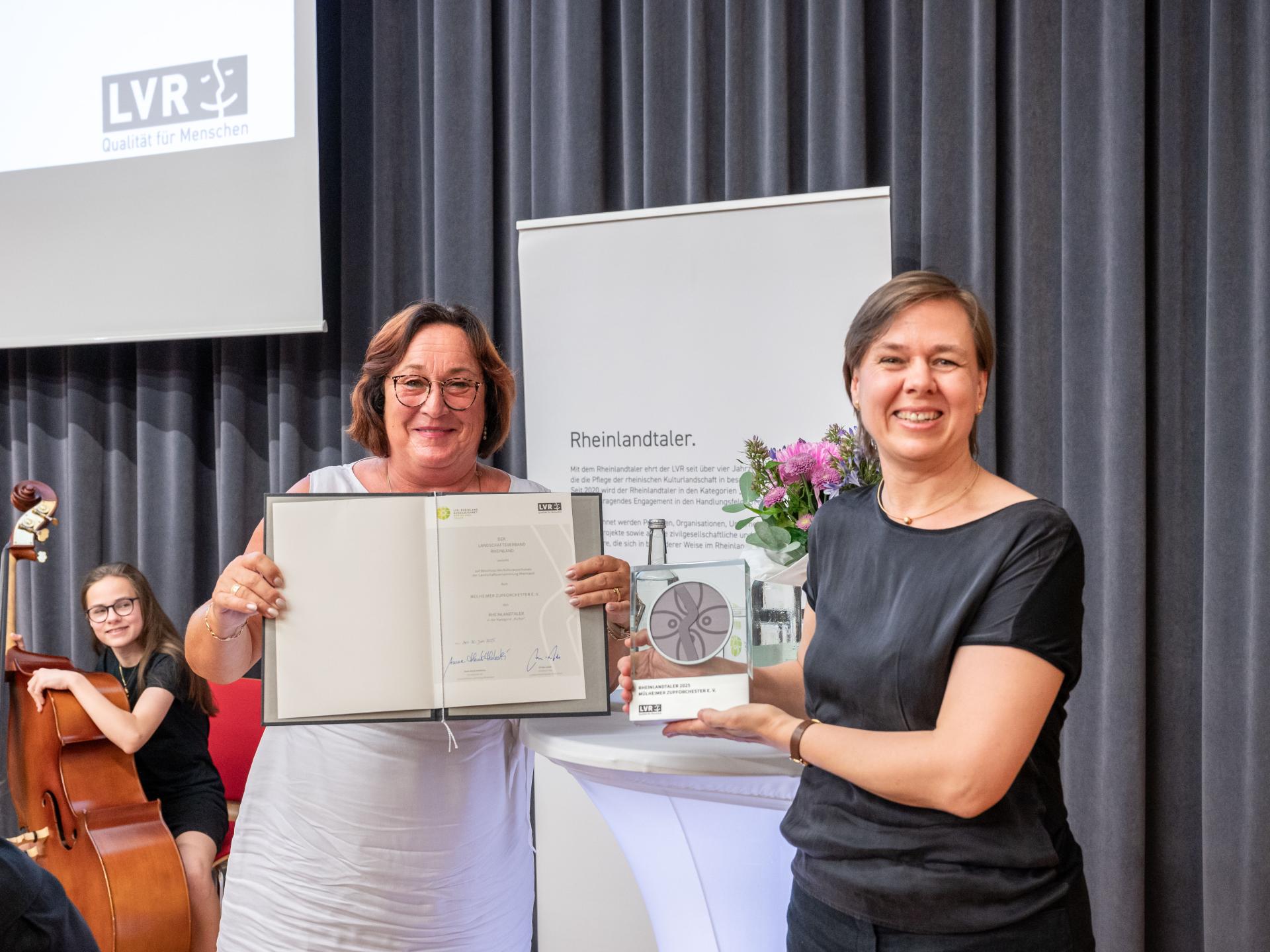 Bei der Übergabe des Rheinlandtalers: Dr. Christiane Leonards-Schippers (links, stellvertretende Vorsitzende der Landschaftsversammlung Rheinland) und Silke Schenck (rechts, Vorsitzende des Mülheimer Zupforchester e.V.).