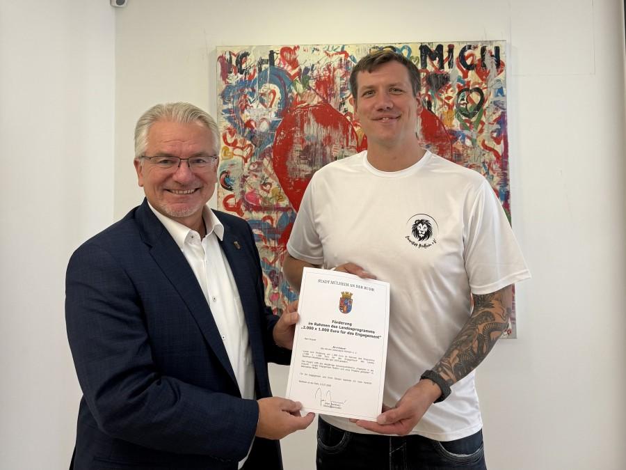  Das Projekt Fit4Future des Vereins Löwenstark Mülheim e.V. wurde im Rahmen des Landesprogramms "2.000 x 1.000 Euro für das Engagement" gefördert (von links nach rechts): Oberbürgermeister Marc Buchholz und 1. Vorstandsvorsitzender des Vereins Löwenstark Mülheim e.V., Kevin Van Boxem. 