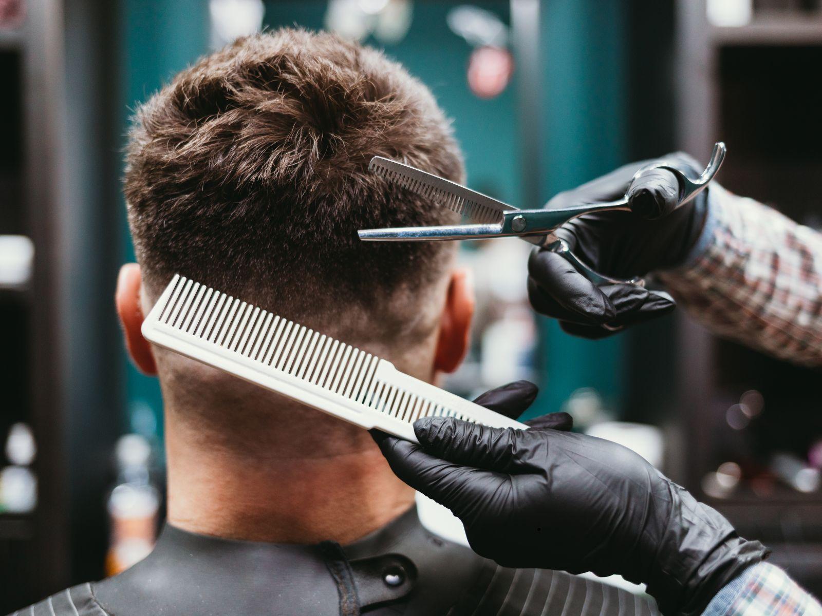 Ein Mann lässt sich beim Friseur die Haare schneiden