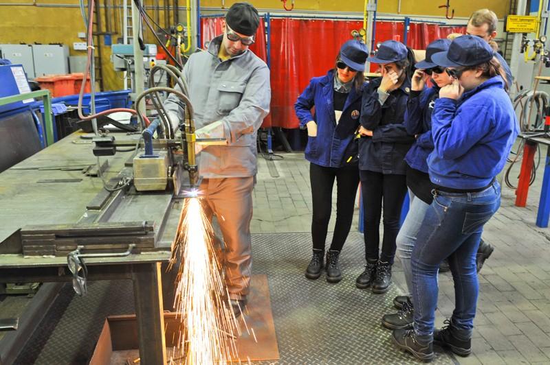Teilnehmerinnen beim Girls Day schauen einem Arbeiter der Firma Vallourec & Mannesmann Tubes V&M Deutschland GmbH zu