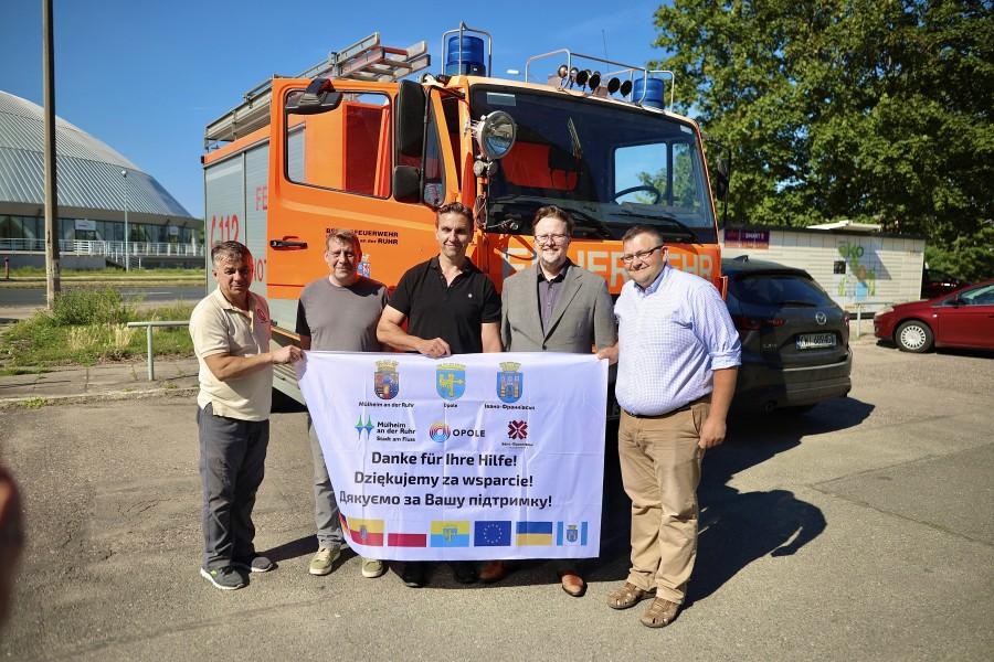 Bei der Übergabe des Feuerwehrfahrzeuges in der gemeinsamen Partnerstadt Opole (von links nach rechts): Ihor Danyleichuk (Fahrer aus Ivano-Frankivsk), Christian Thomas (Feuerwehr Mülheim, Fahrzeugbesatzung), Gregor Przylucki (Feuerwehr Mülheim, Fahrzeugbesatzung), Maciej Wujec (Vizepräsident der Stadt Opole) und Andrii Tiutiunyk (stellvertretender Direktor des „Electroavtotrans“ Ivano-Frankivsk).