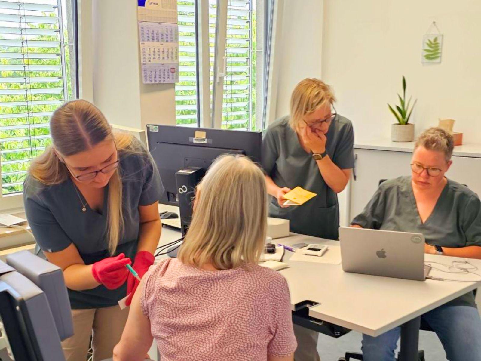 Das dreiköpfige Team der Praxis an den Bahnbögen impft eine Besucherin am Tag der offenen Tür im Gesundheitsamt.
