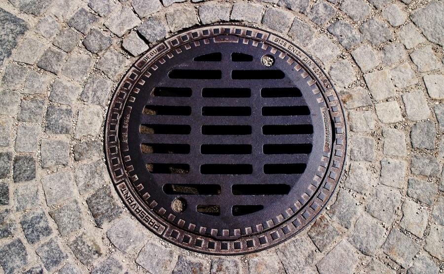 Schachtdeckel auf Kopfsteinpflaster.