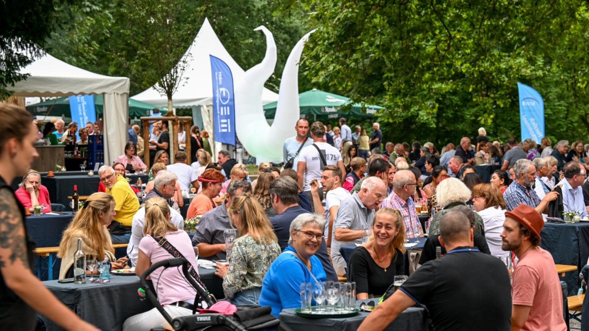 Menschen sitzen beim Kulinarischen Treff zusammen und essen gemeinsam.