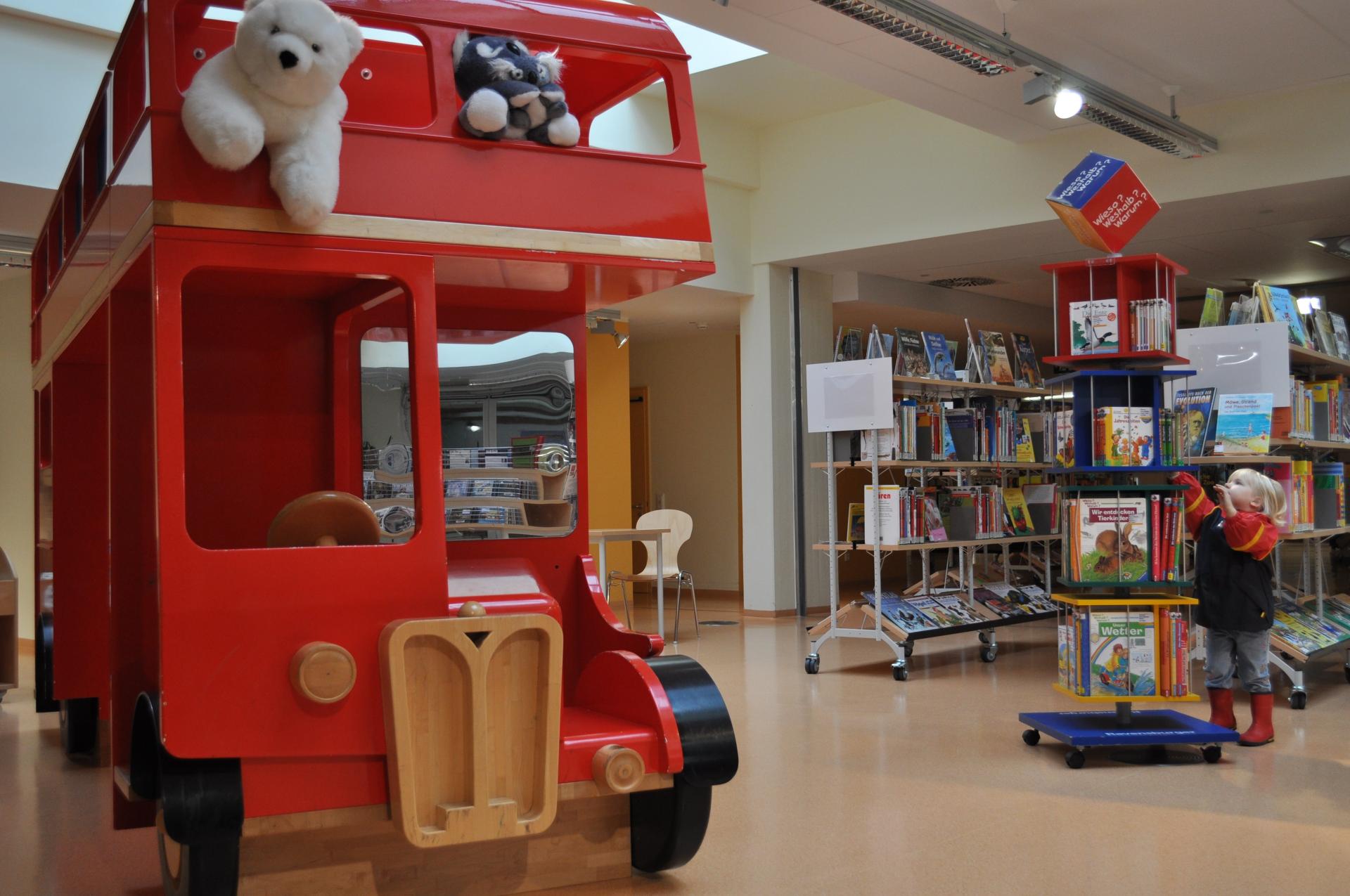 Ein Kind greift nach einem Bilderbuch in der Kinderbücherei in der Stadtteilbibliothek Dümpten