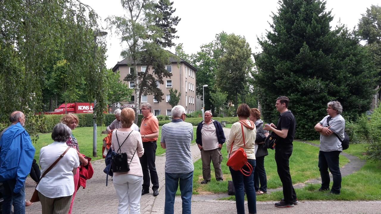 Menschen bei einem Stadtrundgang auf dem Goetheplatz im Mülheimer Dichterviertel