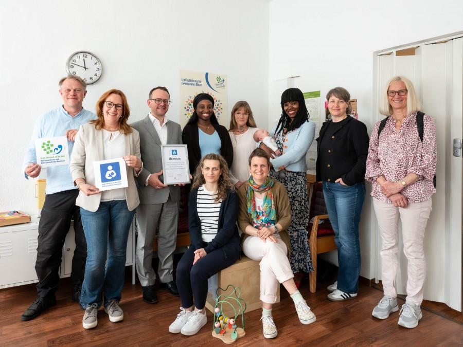 Vertreter der stillfreundlichen Orte präsentieren die Hinweisschilder mit dem stillfreundlichen Logo im Familienhebammenladen in der Wallstraße 5