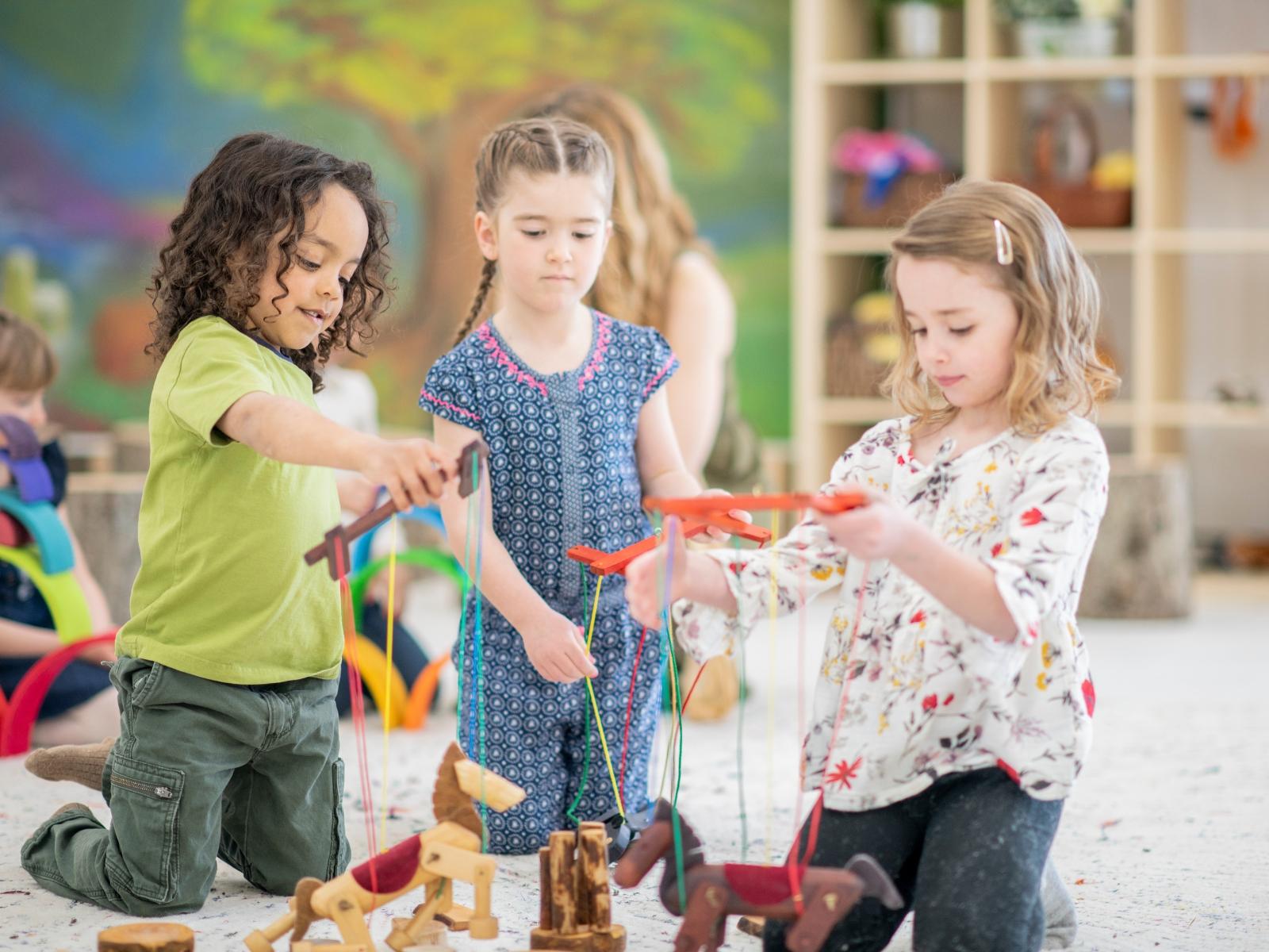 Kinder spielen mit Holz-Marionetten