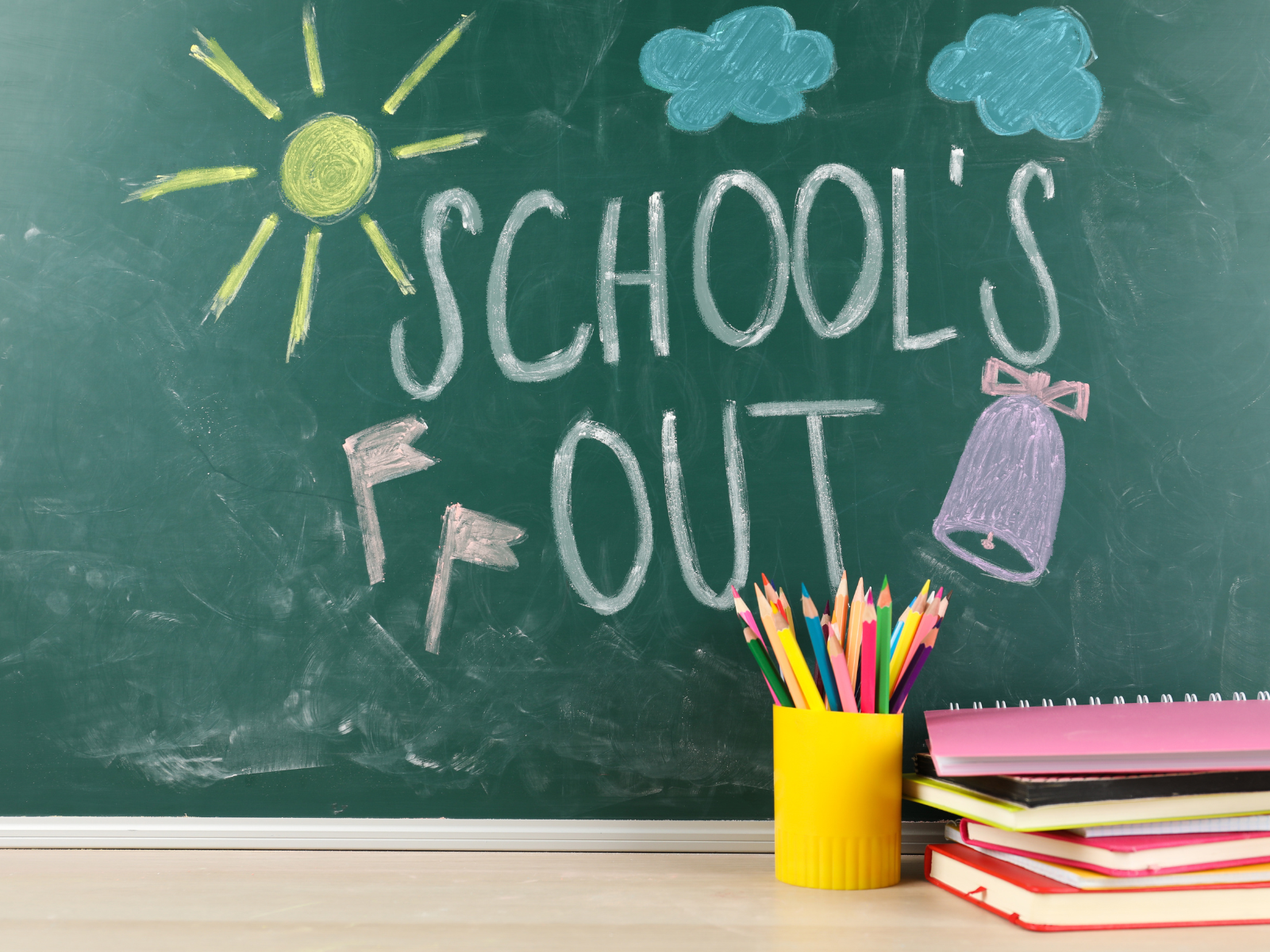 Schultafel mit dem Schriftzug "Schools Out" und weiteren Zeichnungen mit Kreide
