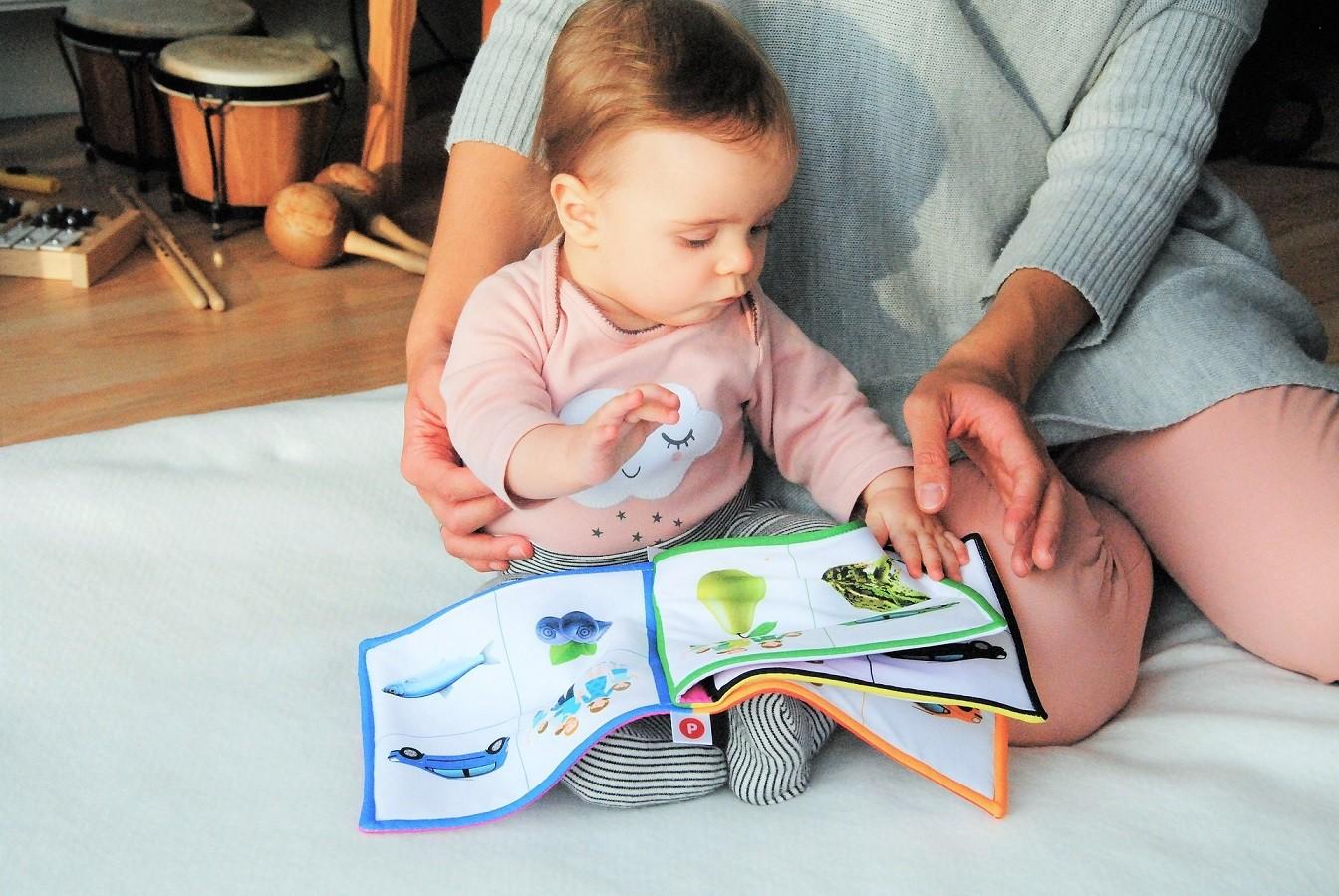 Tagesmutter schaut mit einem Kleinkind in ein Bilderbuch. Kinderbetreuung, Tagesmutter / Tagesvater gesucht!