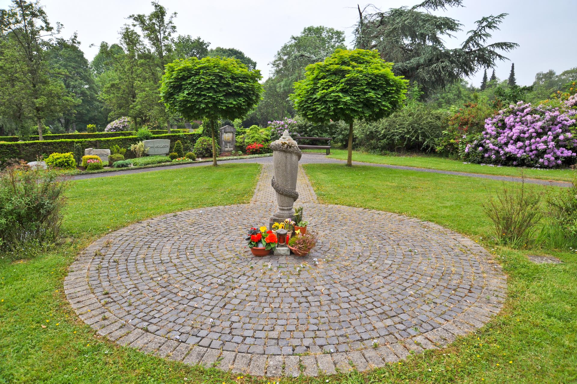 Aschestreufeld auf dem Hauptfriedhof. Ein Gedenkstein in Form einer umrankten Urne wurde mit Blumenablagen geschmückt