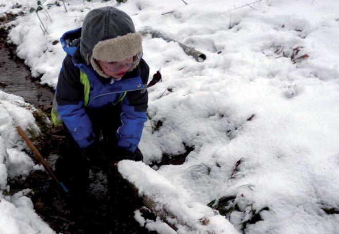 Kleiner Junge spielt im Schnee in der Parkanlage Witthausbusch, Lernwerkstatt Natur. 