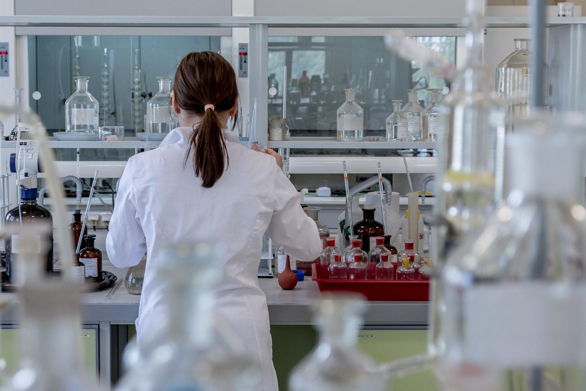 Symbolbild: Analytik im Labor - junge Frau am Labortisch.