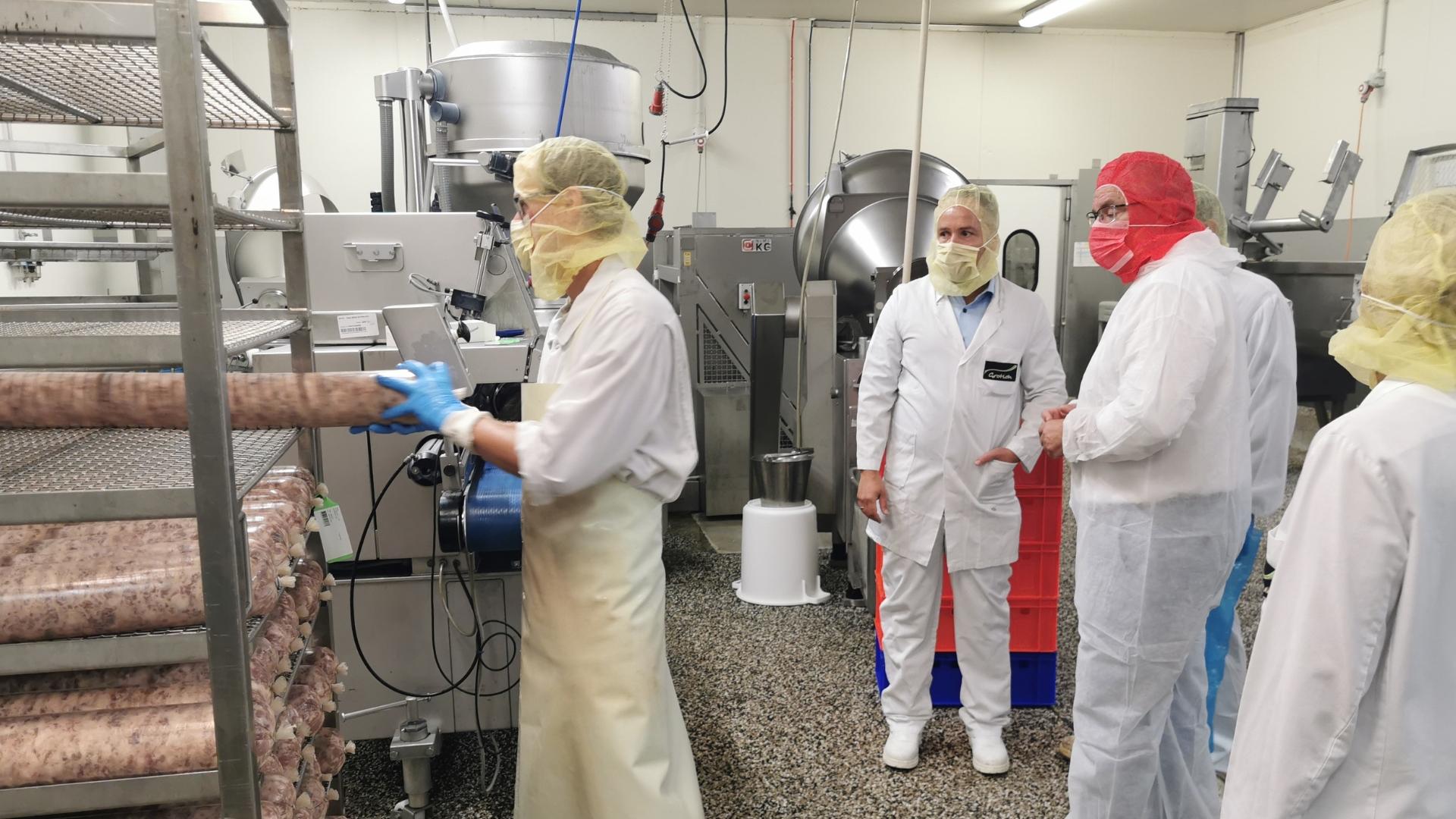 Oberbürgermeister Marc Buchholz mit Mitarbeitenden der Firma Jupiter Kurt Grotloh GmbH in der Fleischerei