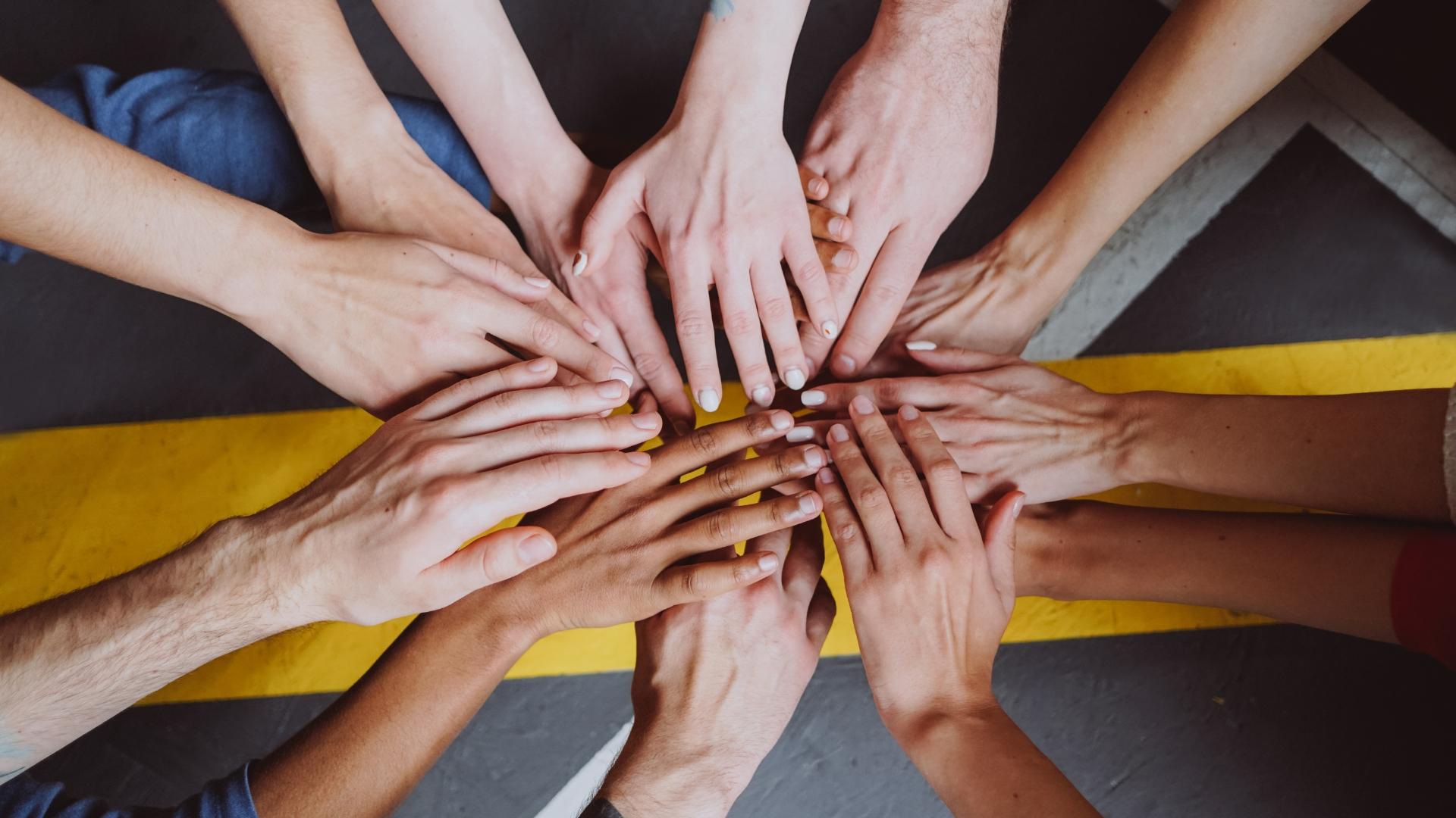Viele Hände treffen sich in der Mitte