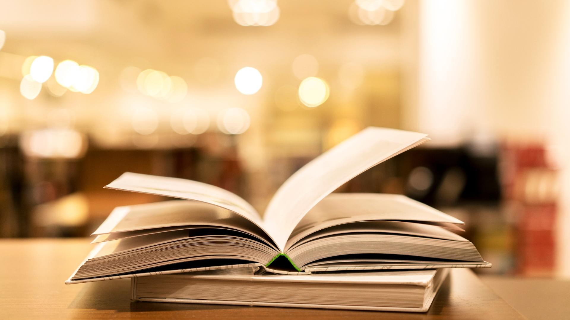 zwei Bücher liegen aufeinander und eins liegt offen
