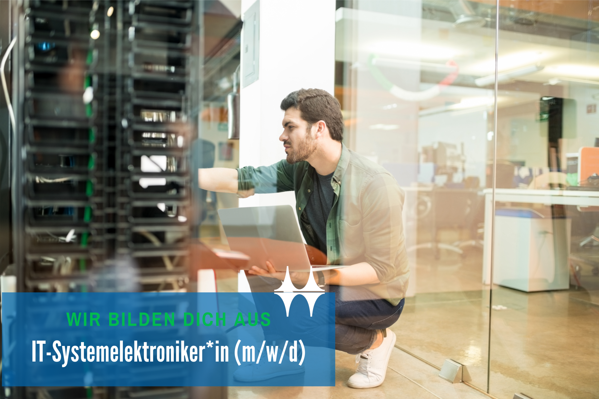 Das Bild zeigt einen jungen Mann hockend vor einem Schaltschrank. Er hält ein Laptop in den Händen und blickt konzentriert auf den Schaltschrank..