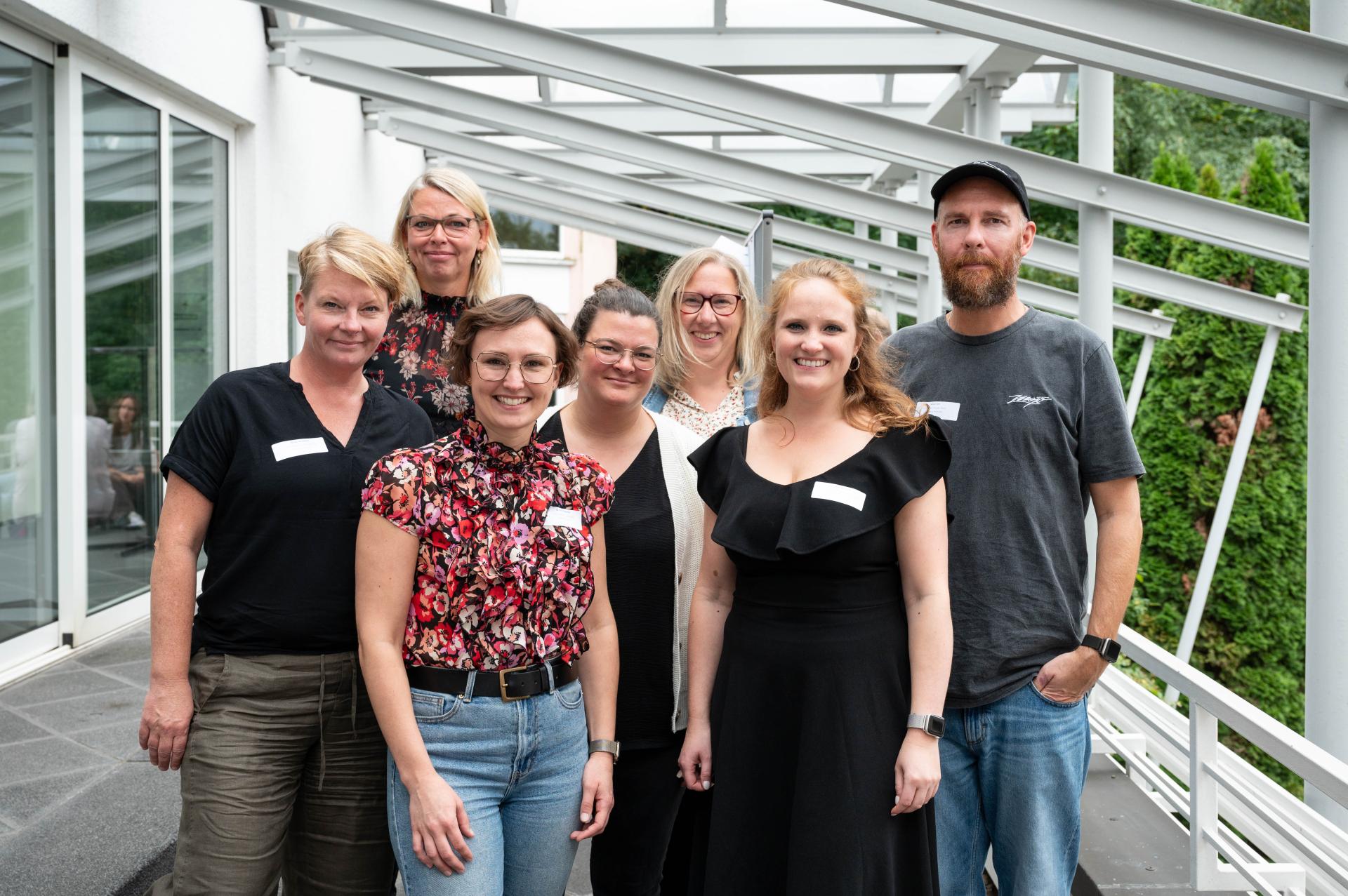 Die fünf Teamleitungen des Allgemeinen Sozialen Dienstes, eine Schulsozialarbeiterin und die Netzwerkkoordinatorin stehen als Gruppe im Außenbereich der Akademie 'Wolfsburg'