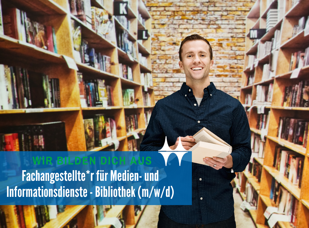 Das Bild zeigt einen jungen Mann, der zwischen Bücherregalen steht. In seinen Händen hält er ein Buch. Er lächelt in die Kamera.