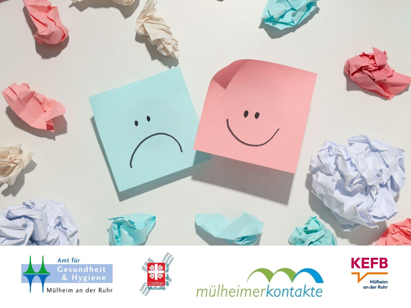 Blauer Post-it mit einem traurigen Gesicht und ein rosa Post-it mit einem fröhlichen Gesicht