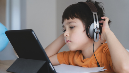 Junger Schüler mit Tablet und Headset