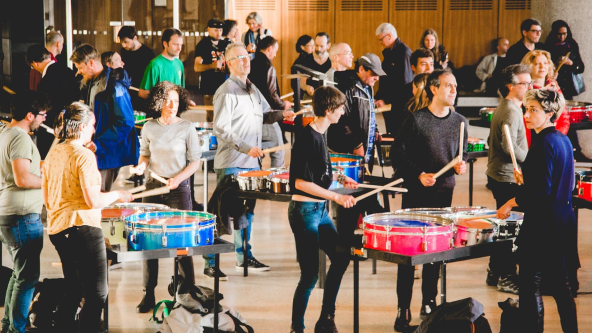 Erwachsene spielen auf einer speziell aufgebauten Percussion-Installation