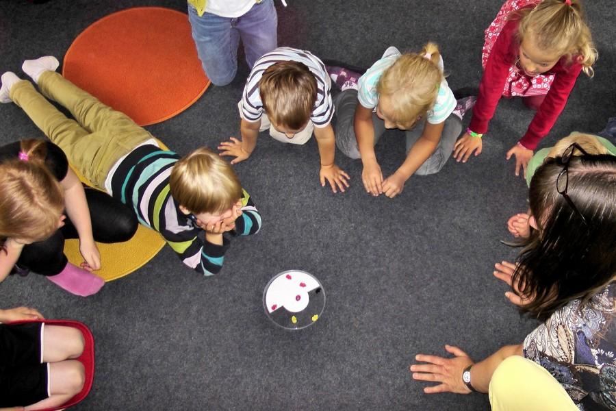 Betreuerin spielt mit Kindern. Infos für Kindertagespflegepersonen.