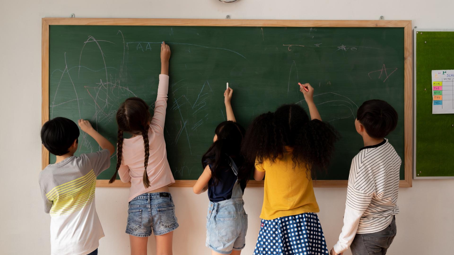 Kinder zeichnen auf Tafel