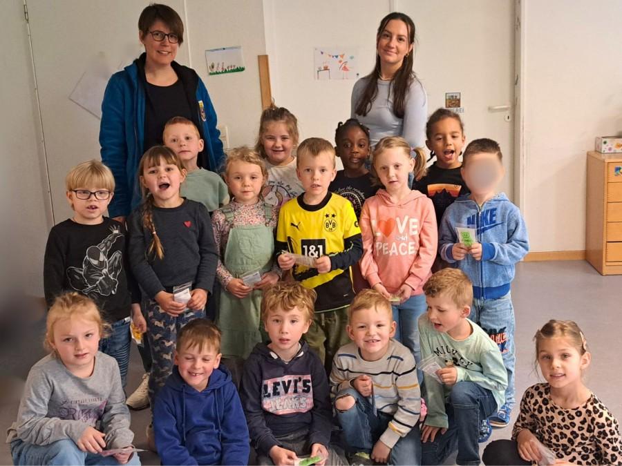 Auf dem Bild befinden sich die Kinder Kinder der Kita Abenteuerland. Oben links steht Dr. Susanne Härtig, oben rechts im Bild Mahrou Dominiak vom Gesundheitsamt Mülheim an der Ruhr.