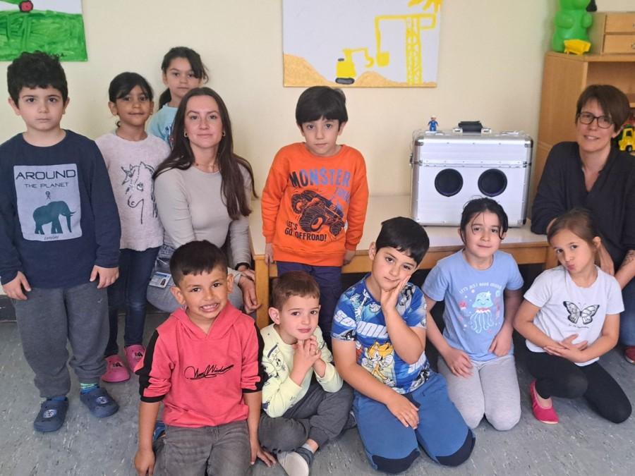 Auf dem Bild sieht man die Kinder von der Kita Regenbogenland. Links im Bild befindet sich Mahrou Dominiak und rechts im Bild Dr. Susanne Härtig vom Gesundheitsamt Mülheim an der Ruhr.