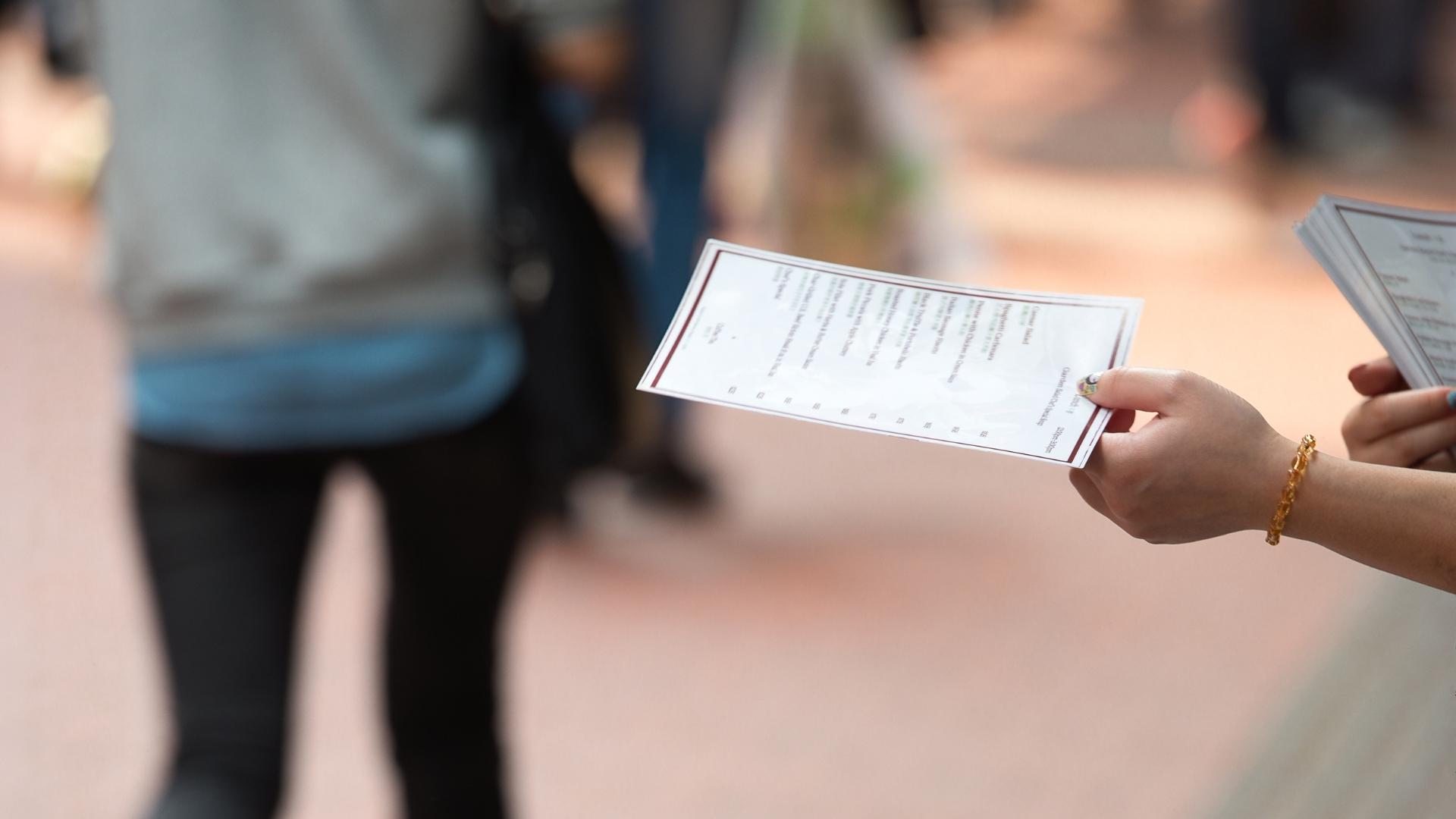 Person verteilt Flyer