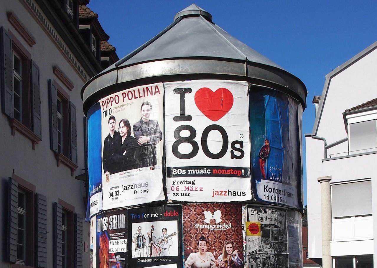 Bildausschnitt einer Litfasssäule mit verschiedenen Werbeplakaten für Konzerte und andere Veranstaltungen.