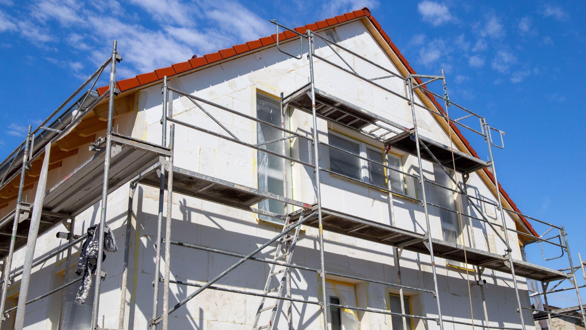 Baugerüst vor weißem Haus