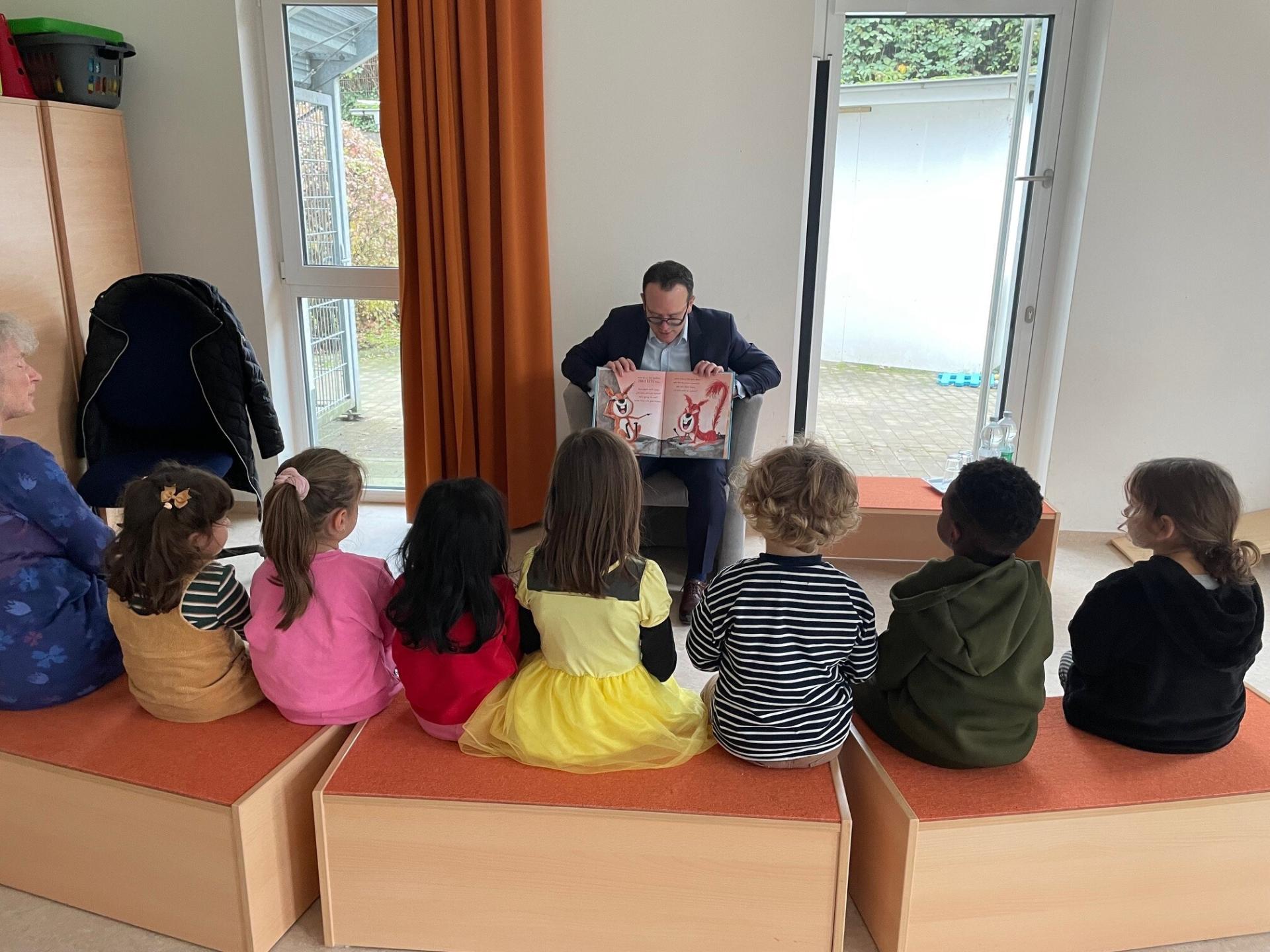 Herr David Lüngen liest den Kindern der KiTa Menschenskinder bei den Mülheimer Vorlesetagen 2024 ein Buch vor.