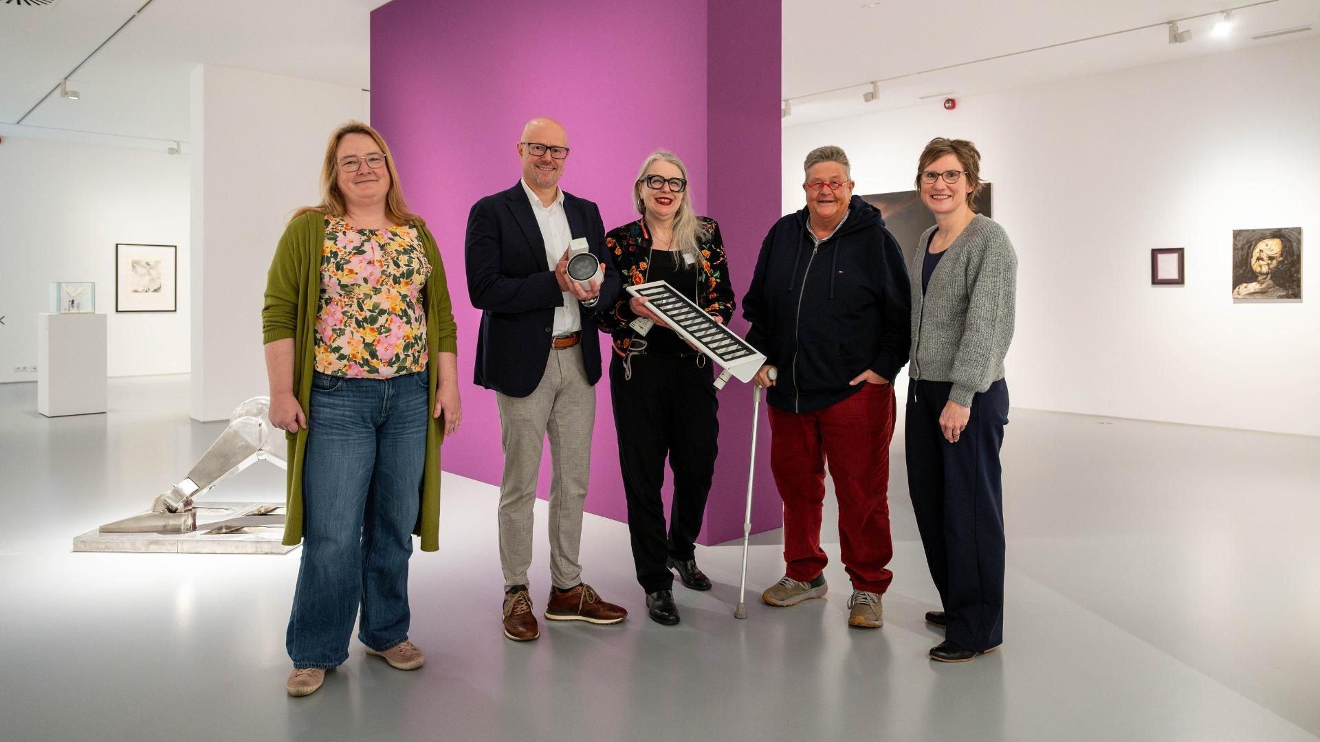 Gruppenfoto in einem Ausstellungsraum des Mülheimer Kunstmuseums, zwei Personen halten Lampen in der Hand.