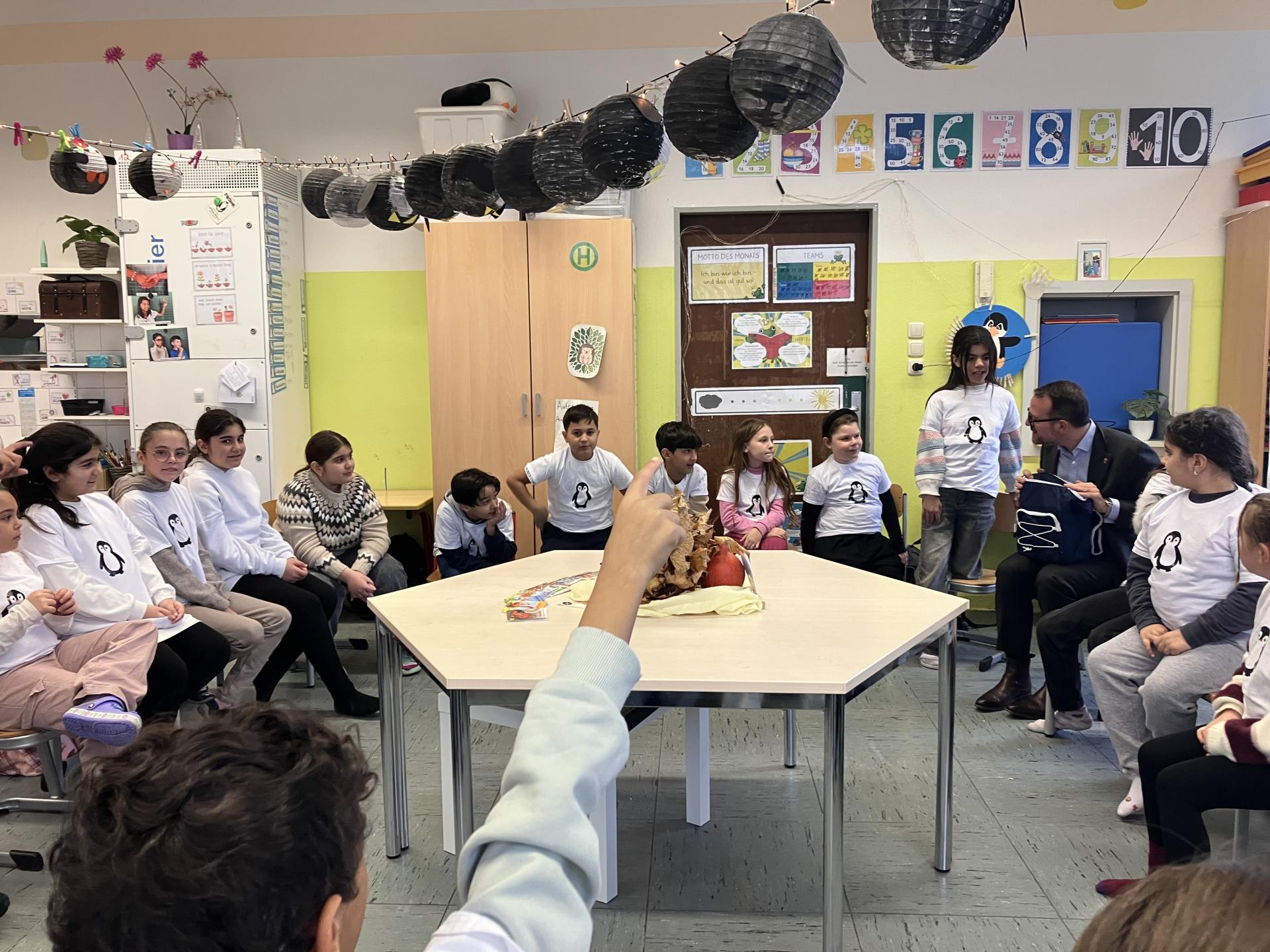 Ein Mann liest Kindern in einem Kreis sitzend vor.