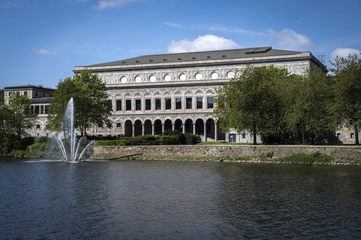 Im Vordergrund die Ruhr mit Fontäne. Im Hintergrund die Rückansicht der Stadthalle.