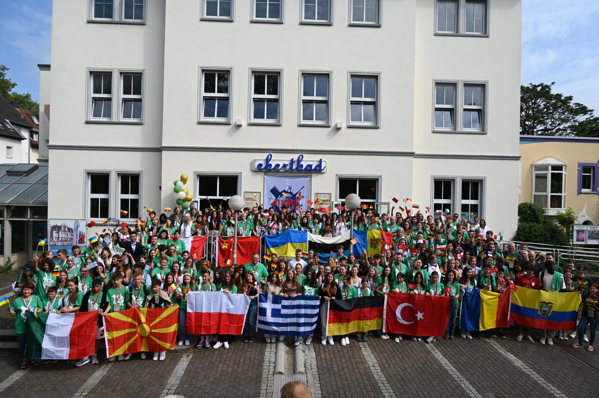 Zu sehen sind die Teilnehmenden des Internationalen Austausches "Multi" 2024 mit den Flaggen der teilnehmenden Nationen.