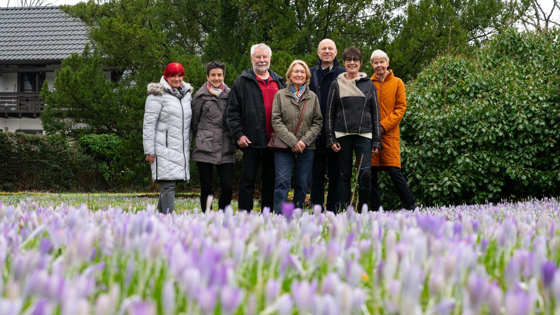 Gruppenfoto auf dem Friedhof Holthausen, im Vordergrund sind blühende Elfen-Krokusse zu sehen.