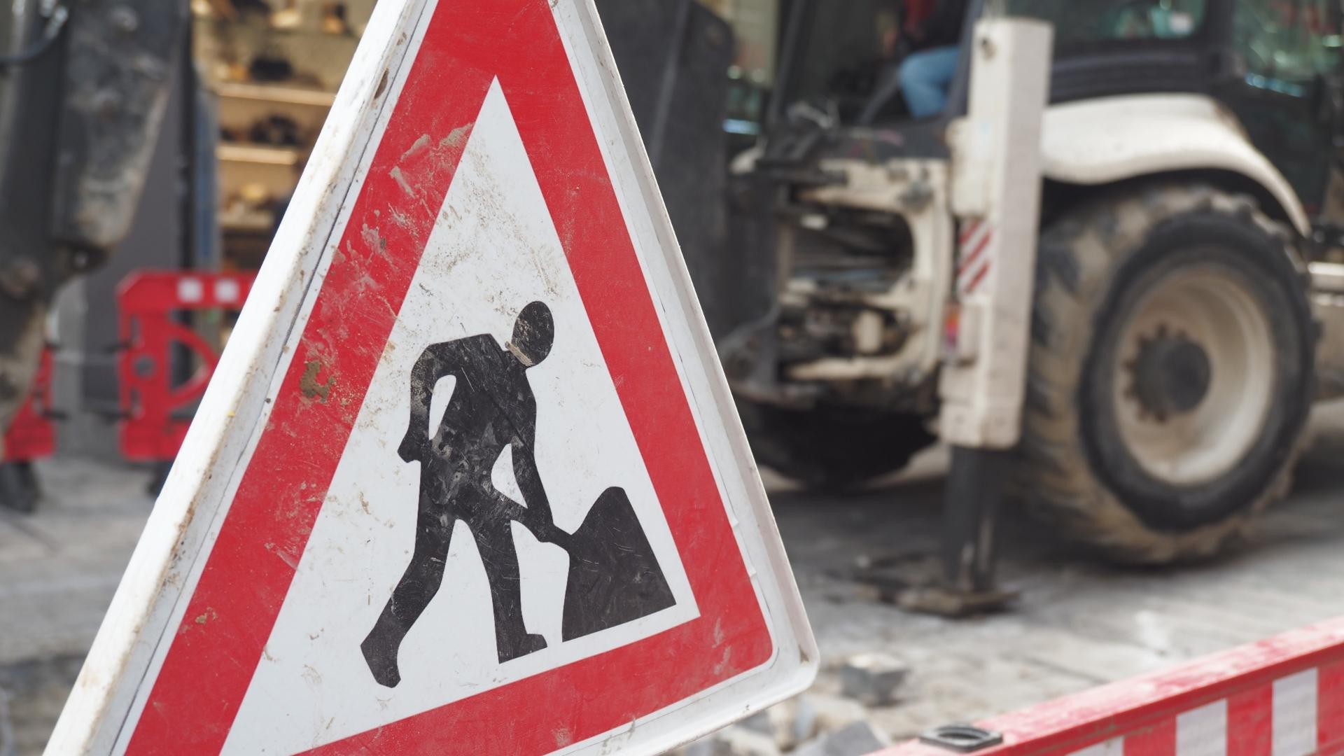 Schild zeigt einen Bauarbeiter mit Schippe, dahinter steht ein Bagger