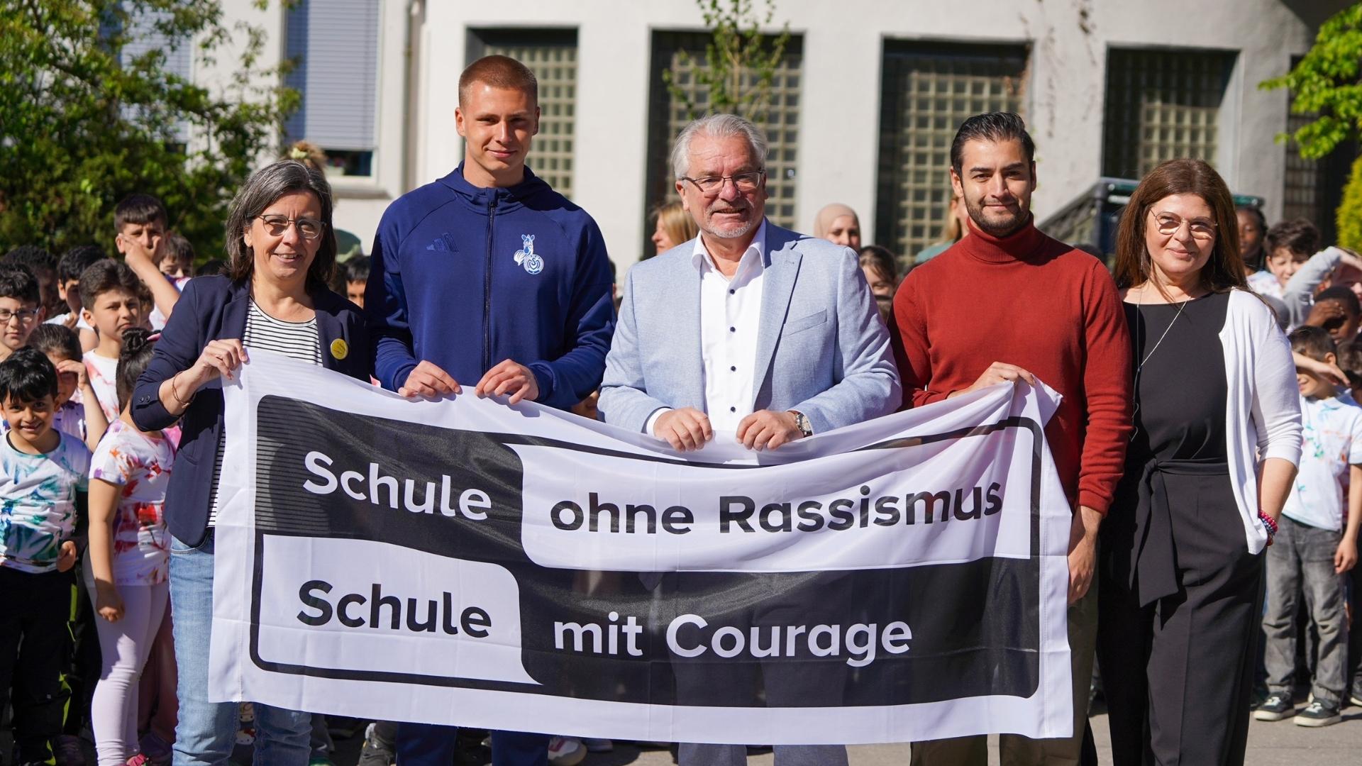 Gruppenfoto mit Banner „Schule ohne Rassismus – Schule mit Courage“ bei der Aufnahmeveranstaltung der Astrid Lindgren-Schule 