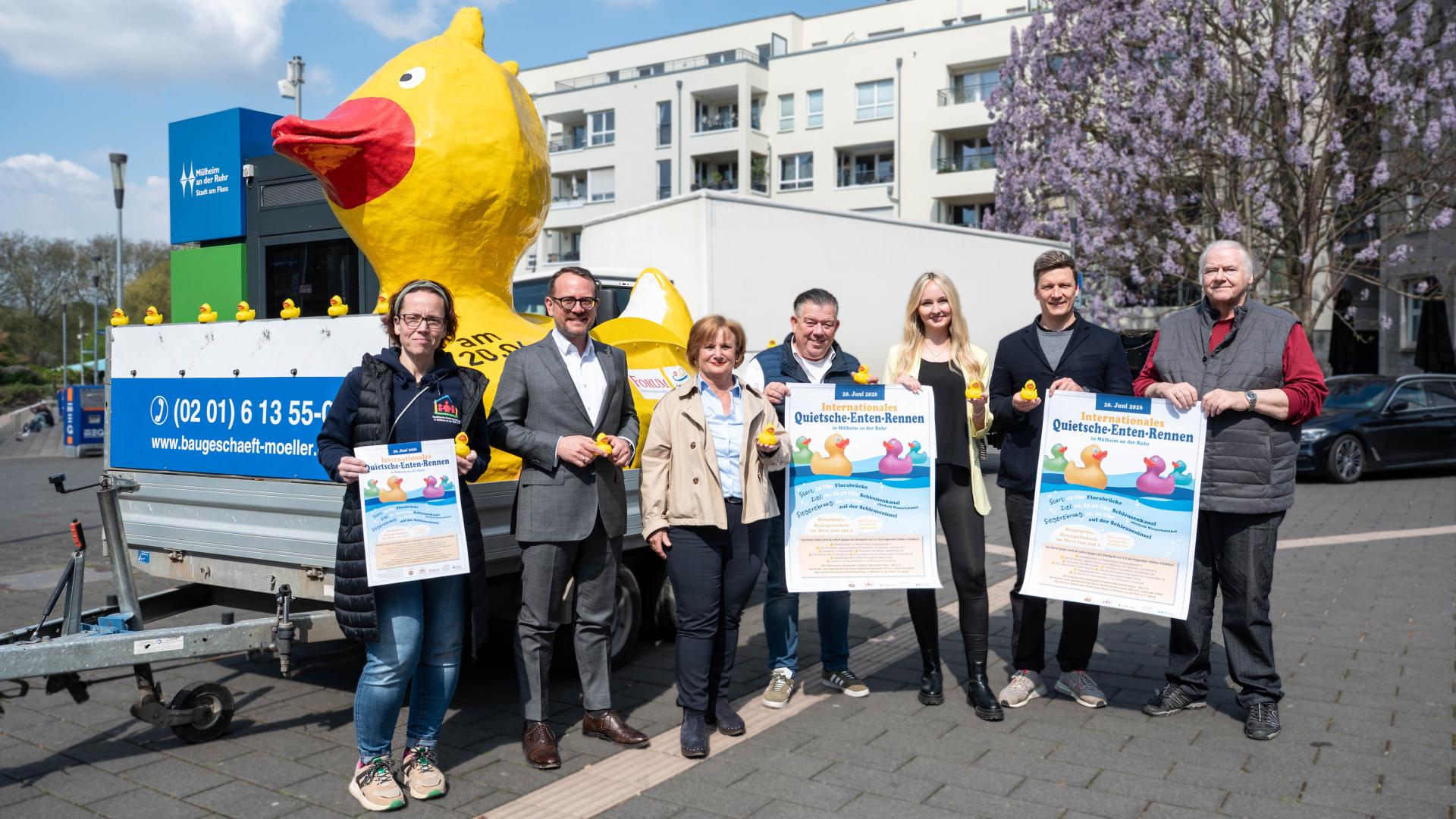 Gruppenfoto vor einer großen gelben Ente am Hafenbecken