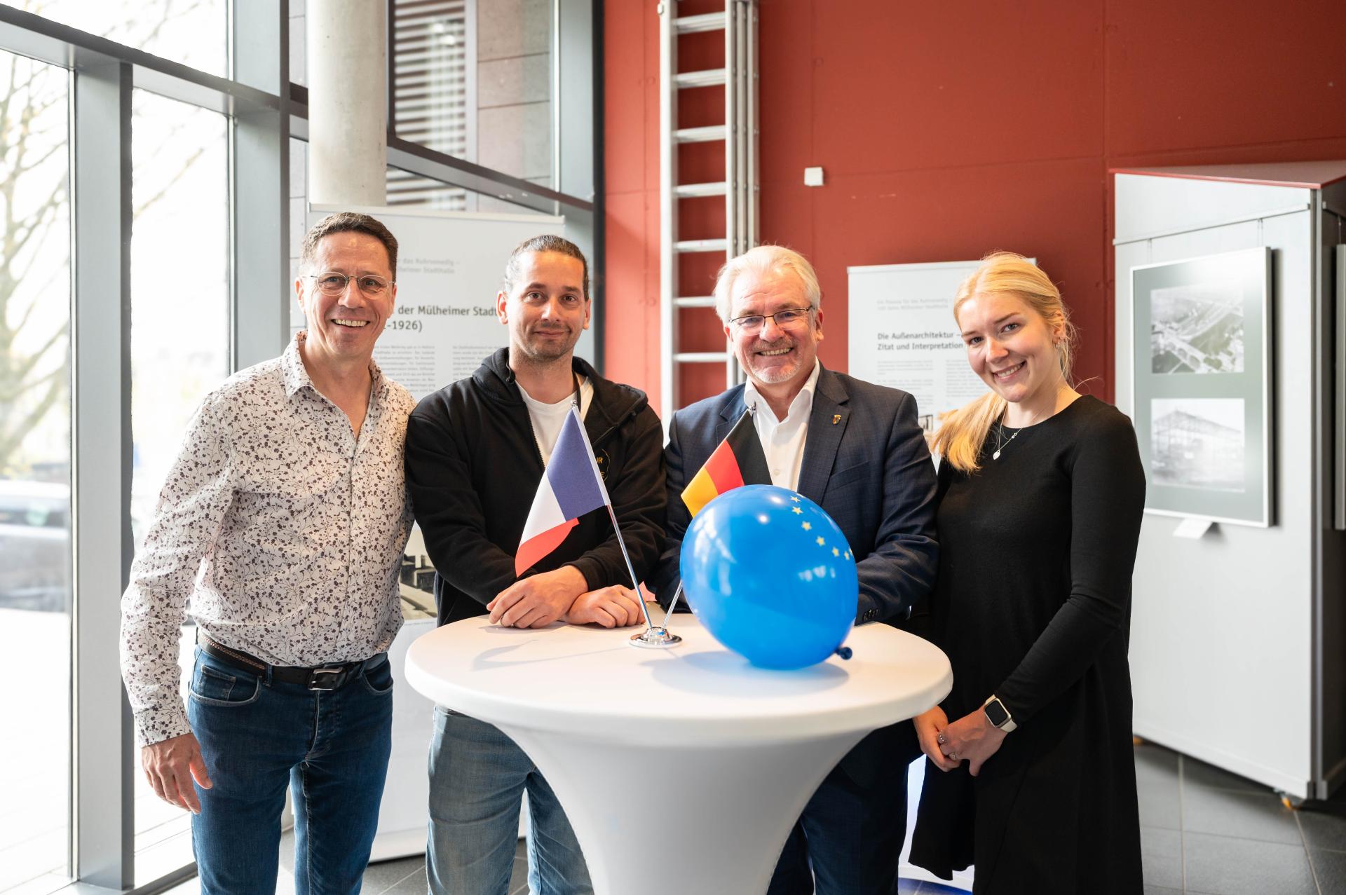 Musikalische Begegnung mit der französischen Partnerstadt Tours (von links nach rechts: Chormitglied und Austauschkoordinator Jacques Robic;  Chorleiter Bastien Flori; Oberbürgermeister Marc Buchholz und Alexandra Taulien (Ref. I.2). 