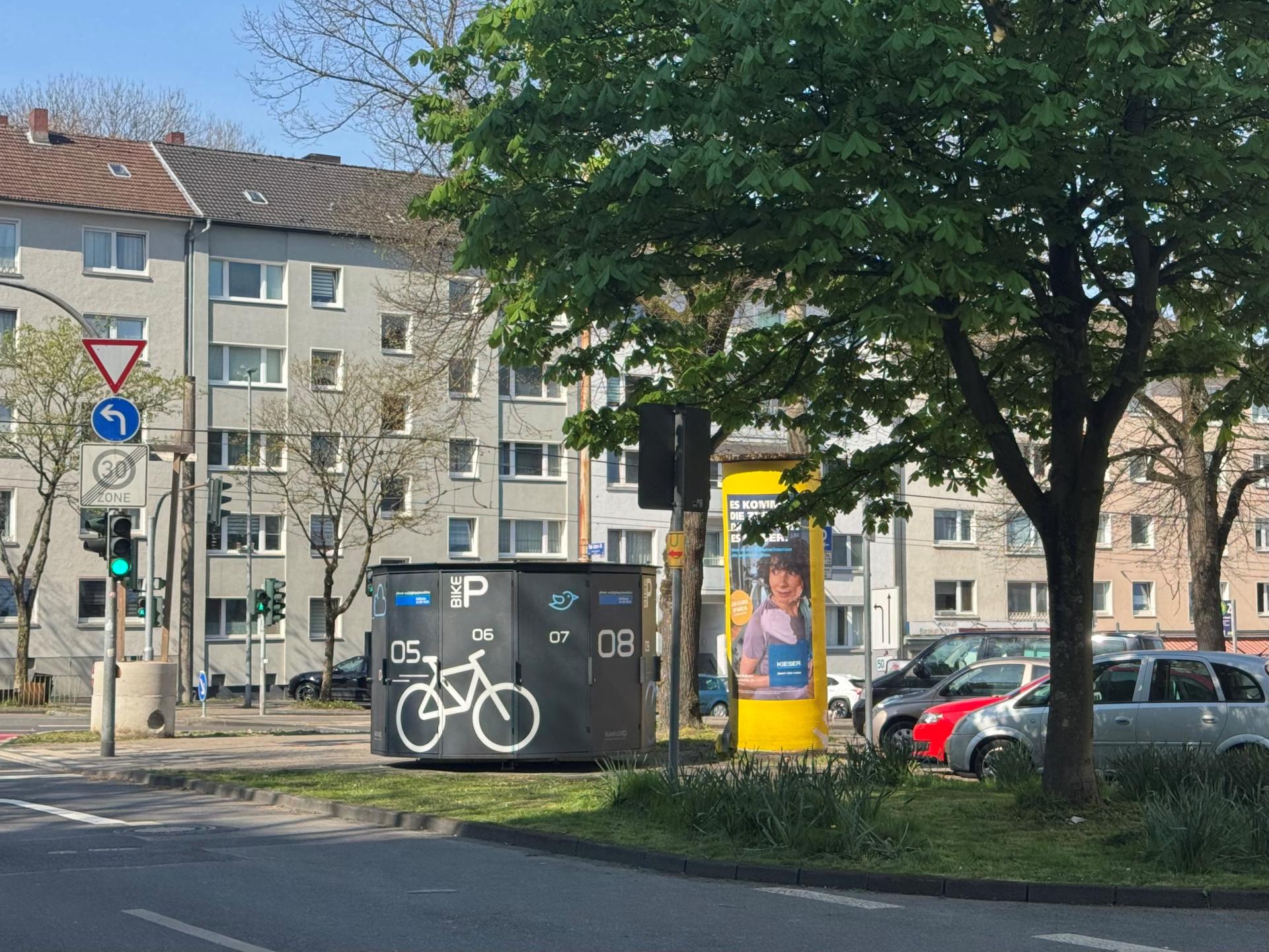 Fahrradhaus im öffentlichen Verkehrsraum, zwischen Ampel und Litfaßsäule