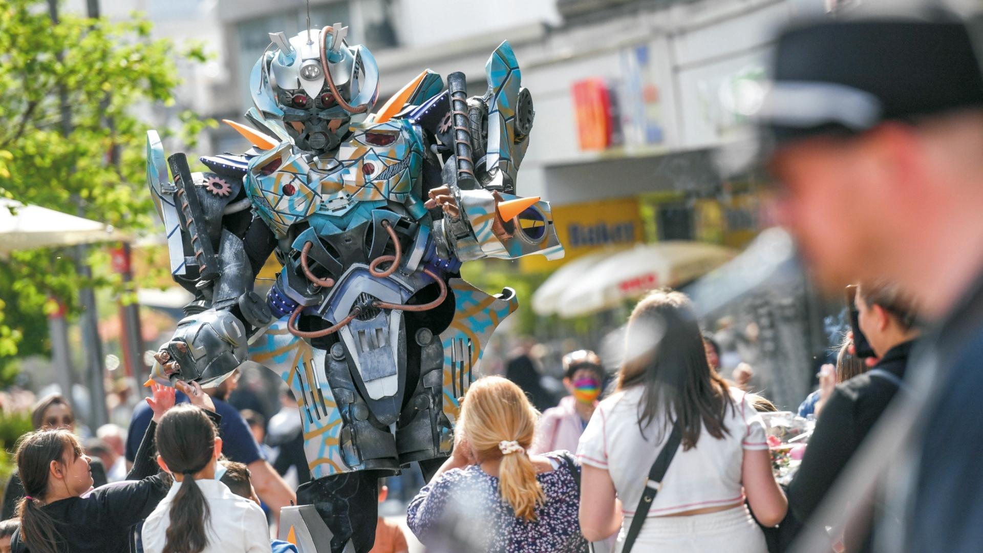 Foto wurde bei der Veranstaltung "Mülheim mittendrin" gemacht. Zu sehen ist ein Musiker, Publikum und ein und Walk Act.