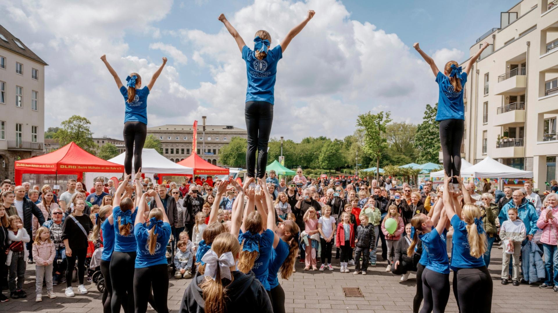 Foto ist bei der Veranstaltung "Tag des Sports" im Mülheimer Stadthafen entstanden. Es zeigt Sportler*innen bei einer Aufführung und Publikum.